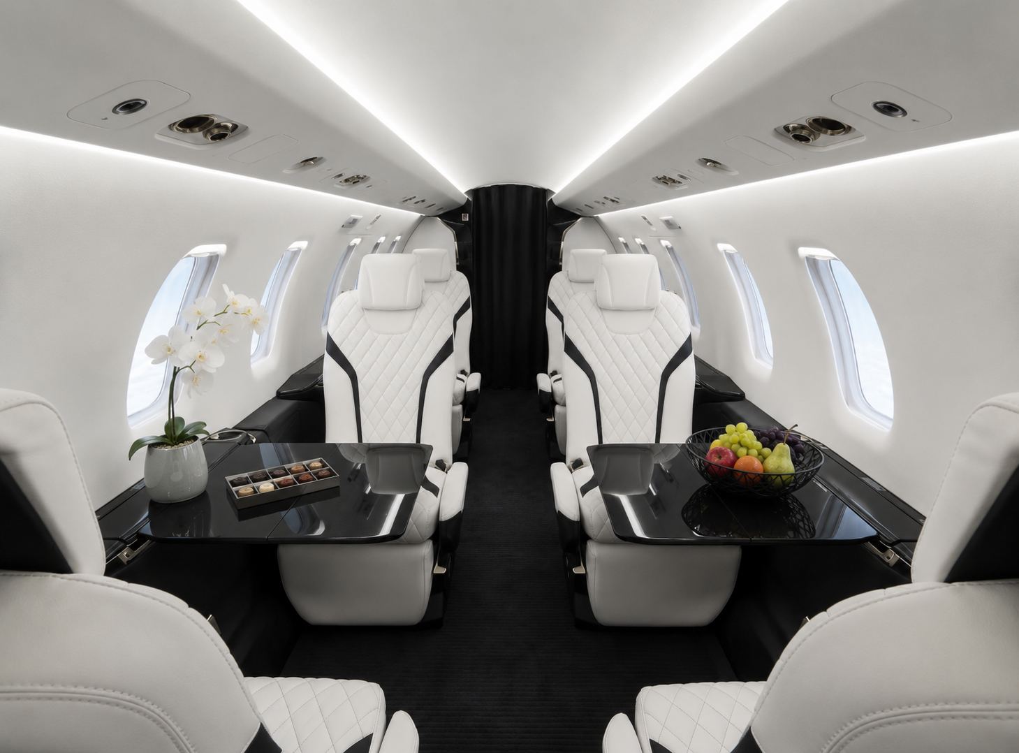 Pilatus PC-24 Cabin – Comfort and Flexibility Luxury cabin of a Pilatus PC-24 private jet with white leather seats, a spacious aisle and a modern black-and-white interior.