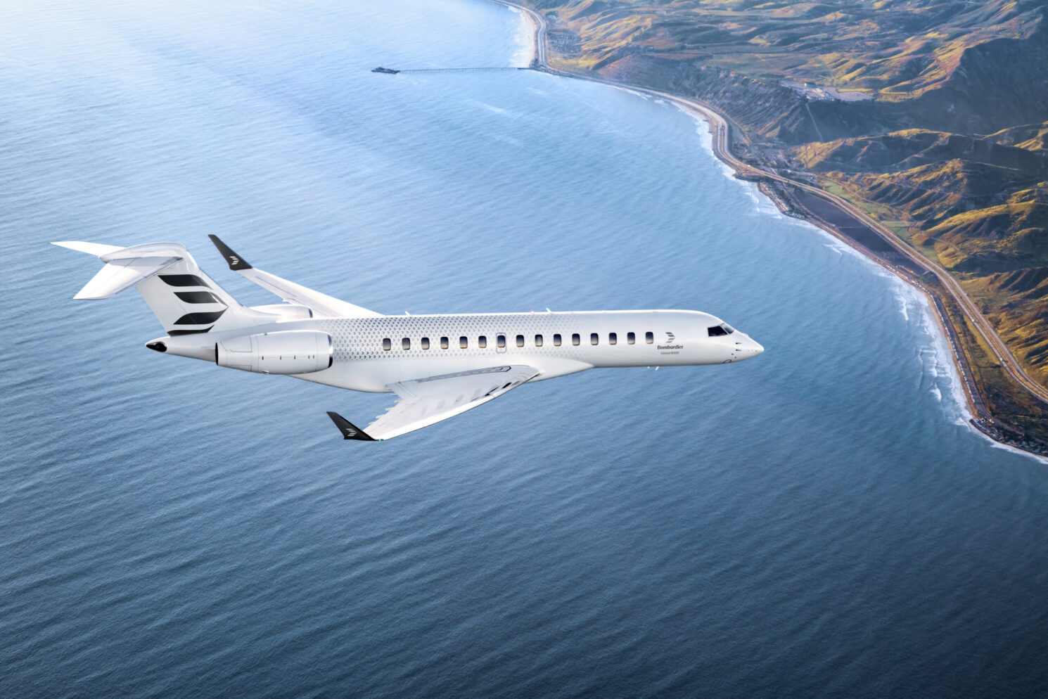 White Bombardier Global 8000 business jet flying over the sea beside a mountainous coastline.
